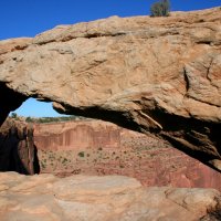 Skalní oblok Mesa Arch se pne nad hranou strže
